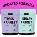 Two PetzPark cat supplement pouches shown side by side on a bright pink background with large black text reading 'UPDATED FORMULA' above. The left pouch is lavender and labeled 'STRESS + ANXIETY' with a fish icon; the right pouch is pale aqua and labeled 'URINARY + KIDNEY' with a cranberry icon.
