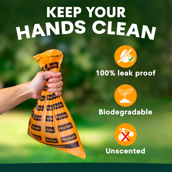 Hand holding a biodegradable waste bag with greenery in the background